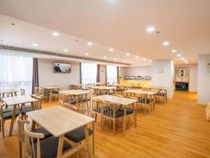a restaurant with tables and chairs in a room at GreenTree Inn Jiangsu Huai'an Qiangjiangpu District Shuidukou Avenue in Huai'an