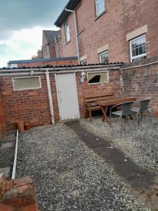 un edificio de ladrillo con una mesa de picnic y una puerta blanca en Grantham Town Centre, en Lincolnshire