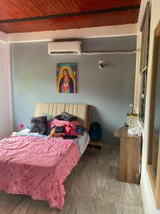 Un dormitorio con una cama con una manta rosa. en Casa Finca campestre, en San José del Guaviare