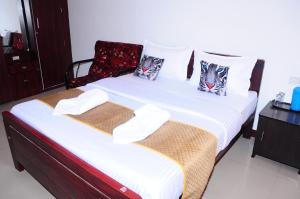 乌提A L Residency的配有椅子的客房内的两张单人床 更多2张照片