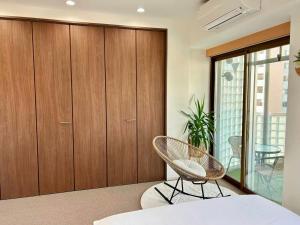 a bedroom with wooden cabinets and a chair at Ansou house 大阪ドーム in Osaka