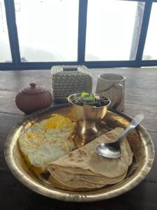 een bord eten met eieren en een kom salade bij Community Lodge Nepal - Chhimeki Lodge in Nagarkot