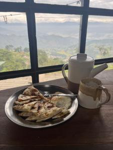 een bord eten op een tafel met een kopje koffie bij Community Lodge Nepal - Chhimeki Lodge in Nagarkot +13 foto's
