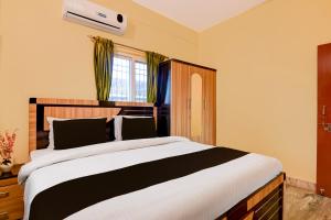 a bedroom with a large bed and a window at Super Hotel O Birsa Athletics Stadium Formerly De Anmol Suites in Nāmkom