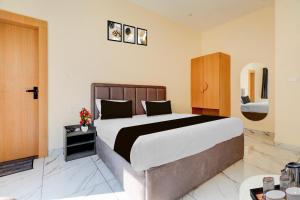 a bedroom with a large bed and a sink at Super Townhouse Oak Army Aviation Base Jhansi in Jhānsi