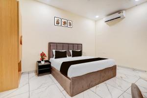 a bedroom with a large bed with white walls at Super Townhouse Oak Army Aviation Base Jhansi in Jhānsi +22 photos