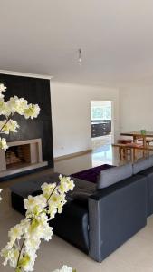 a living room with a black couch and a fireplace at Villa Quinta Dom Reis in Batalha