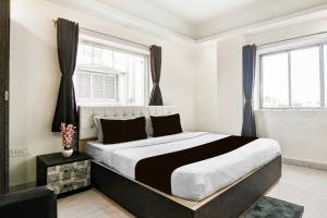 SaluaにあるSuper Collection O City Center New Town Kolkata Formerly Paradise Innの大きなベッドと2つの窓がある寝室