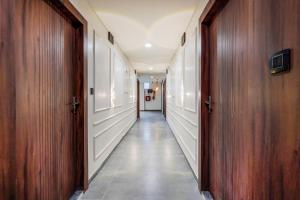 a corridor of a hallway with wooden doors and a hallwayngth at Super Townhouse GIDC Bol Sanand in Ahmedabad