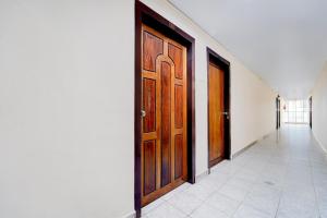 Un pasillo con dos puertas de madera y un pasillo con en Super Hotel O Pathanamthitta Near Mahatma Gandhi Statue, en Pathanāmthitta