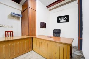 Un mostrador de madera en una habitación con un cartel en la pared. en Super Hotel O Pathanamthitta Near Mahatma Gandhi Statue, en Pathanāmthitta