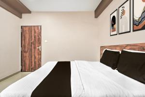 a bedroom with a large bed with black pillows at Super Collection O Palampur Surat Formerly Hotel Royal Paradise in Bhatha +22 photos