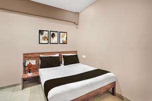 a bedroom with a bed with white and black sheets at Super Collection O Palampur Surat Formerly Hotel Royal Paradise in Bhatha