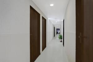 a hallway with wooden doors and a potted plant at Super Collection O Palampur Surat Formerly Hotel Royal Paradise in Bhatha