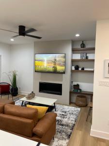 a living room with a flat screen tv on a wall at Downtown New 3 Story Sleeps 14 in Baton Rouge