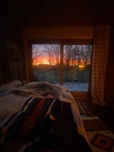 a bedroom with a bed and a window with a view at Romantic Retreat Close To The Beach in Fårevejle