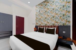 a bedroom with a large bed with a painting on the wall at Super Townhouse Thondayad Calicut Formerly Dream Casa in Kakkayam