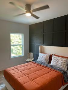 a bedroom with a large bed with a ceiling fan at Downtown New 3 Story Sleeps 14 in Baton Rouge