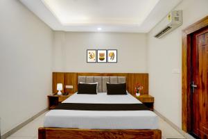 a bedroom with a large bed and two tables at Super Townhouse Varanasi City Station Formerly S Kumar Inn in Varanasi