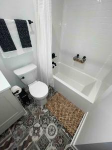a bathroom with a toilet and a bath tub at Downtown New 3 Story Sleeps 14 in Baton Rouge