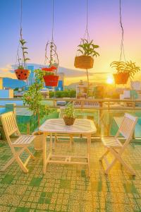 a patio with a table and chairs and potted plants at Gia Hoang Hotel in Quy Nhon