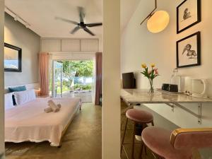 a bedroom with a bed and a table with a desk at Smell rose beach garden in Batu Ferringhi