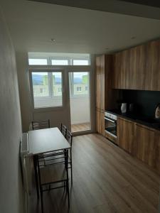 a kitchen with a table and chairs in a room at Apartmán s 2 spálňami in Prievidza
