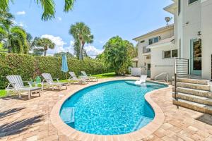 una piscina con sillas y una casa en The Sun Dial - 827, en Siesta Key