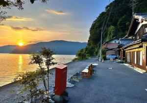 una strada accanto a uno specchio d'acqua con un tramonto di Kokuwaan - Vacation STAY 69575v a Nagahama