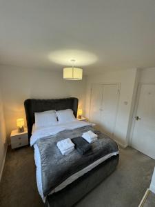Un dormitorio con una cama grande con dos toallas encima. en Your Twickenham Nest Near The Stadium, en Twickenham