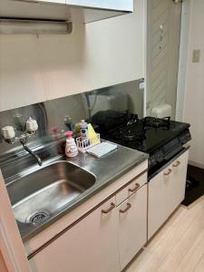 a kitchen with a sink and a stove at KIYAZA Road Sapporo in Sapporo