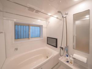 a white bathroom with a tub and a window at さくら旅館阿佐谷北千利休 in Tokyo +39 photos