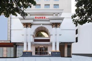YingheにあるVienna Hotel Anhui Fuyang Yingshang Yingbin Avenueのアーチのある大きな白い建物