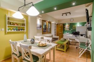 a dining room and living room with a table and chairs at Plaka Studios in Karfas