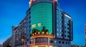 a tall green building with a sign on it at Vienna Hotel Yongzhou Dong'an High-Speed Railway Station in Guzhuting