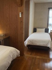 a bedroom with two beds and a window at お休み処おおはま in Yomitan