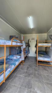 a room with three bunk beds in it at Tez's Backpacking Lodge in Maria