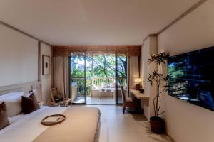 a bedroom with a large bed and a living room at Wanan Tinglan Wild Luxury Resort Designer Hotel in Jinghong