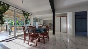 a dining room with a table and chairs at La Maison Plage et Sunset in Paeau