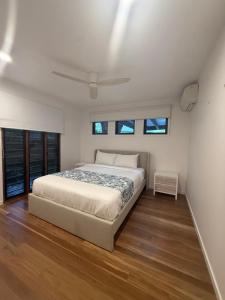 ein weißes Schlafzimmer mit einem Bett und Fenstern in der Unterkunft 2 Bed- Beach and Bush Retreat- Yaroomba-Sunshine Coast in Yaroomba