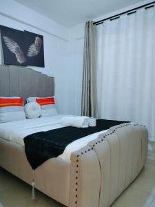 een slaapkamer met een groot bed met een groot raam bij Cutie homes -Trm drive in Nairobi
