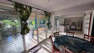 a kitchen and dining room with a table and chairs at La Maison Plage et Sunset in Paeau +80 photos