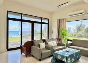 a living room with a couch and a table at 月伴灣海景沙灘民宿 in Beinan