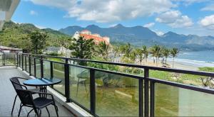 a balcony with a table and chairs and a view of the beach at 月伴灣海景沙灘民宿 in Beinan