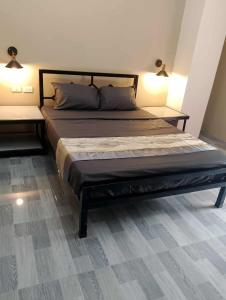 Una cama grande en una habitación con dos lámparas. en American Roadhouse Hotel and Restaurant, en Candijay