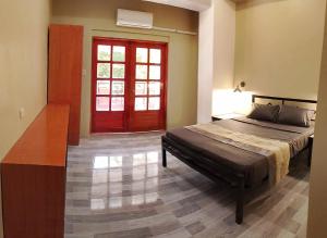 a bedroom with a bed and a red door at American Roadhouse Hotel and Restaurant in Candijay