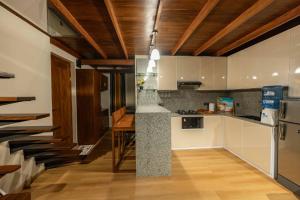 a kitchen with white cabinets and a wooden ceiling at Sakun villa in Mirissa