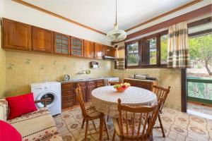 a kitchen with a table and a sink and a stove at Villa Agia Galini in Archangelos