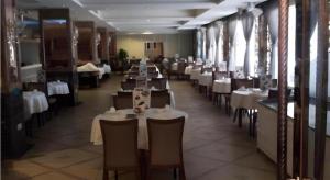 uma sala de jantar com mesas e cadeiras brancas num restaurante em Shenzhen Nan Fei Yuan Hotel em Shenzhen