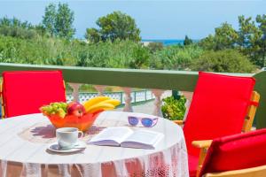 a table with a book and a bowl of fruit and a cup at Villa Agia Galini in Archangelos +4 photos